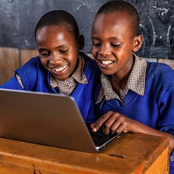 非洲的两个男生对着笔记本电脑微笑