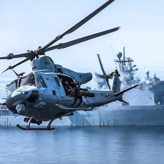 UH-60 flying by an aircraft carrier out at sea